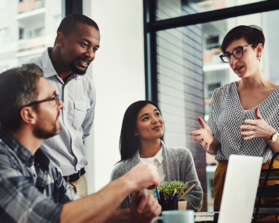 Group of four diverse professional men and women chatting.